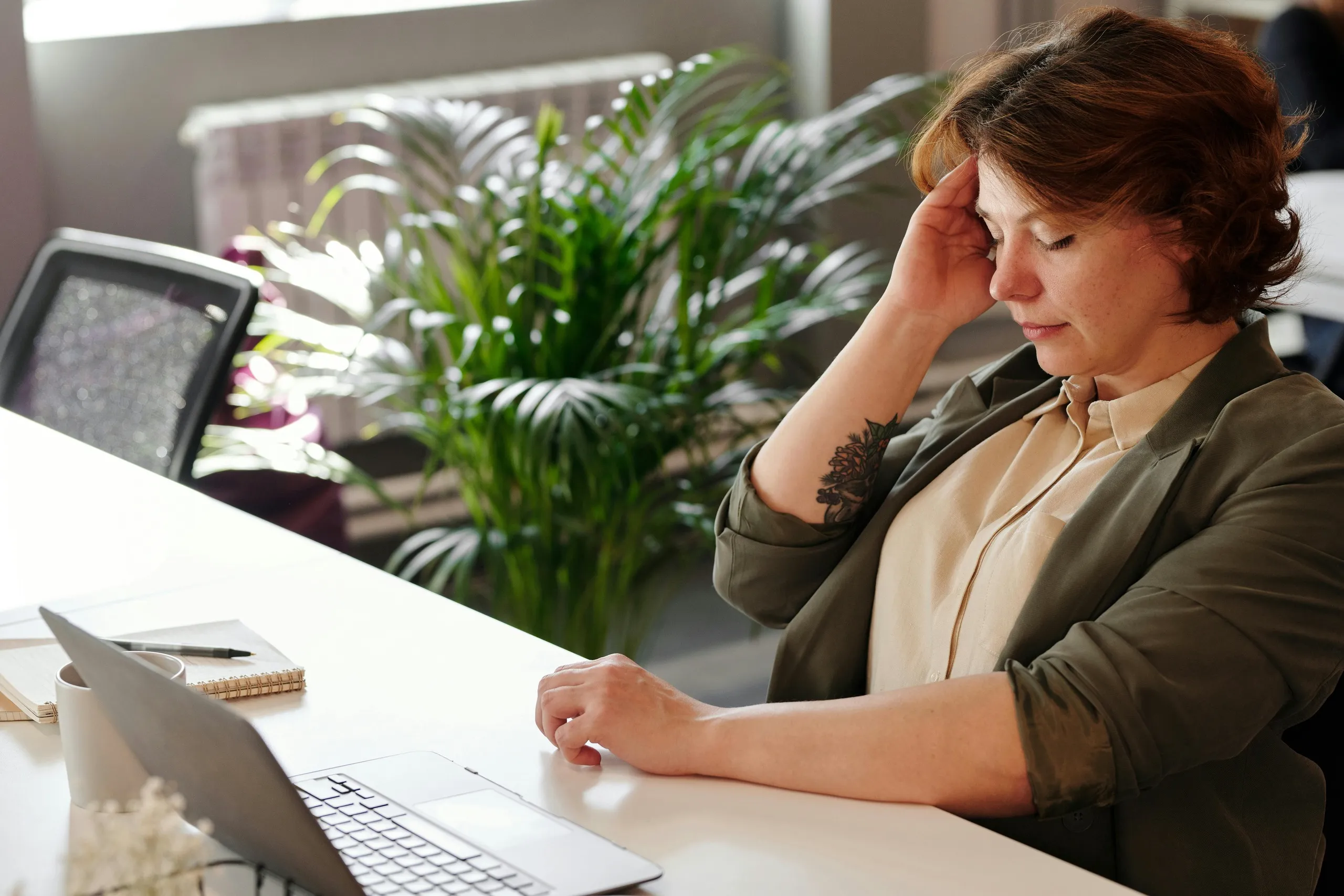 A woman reflects at her desk, considering the effectiveness of her current digital marketing strategy.