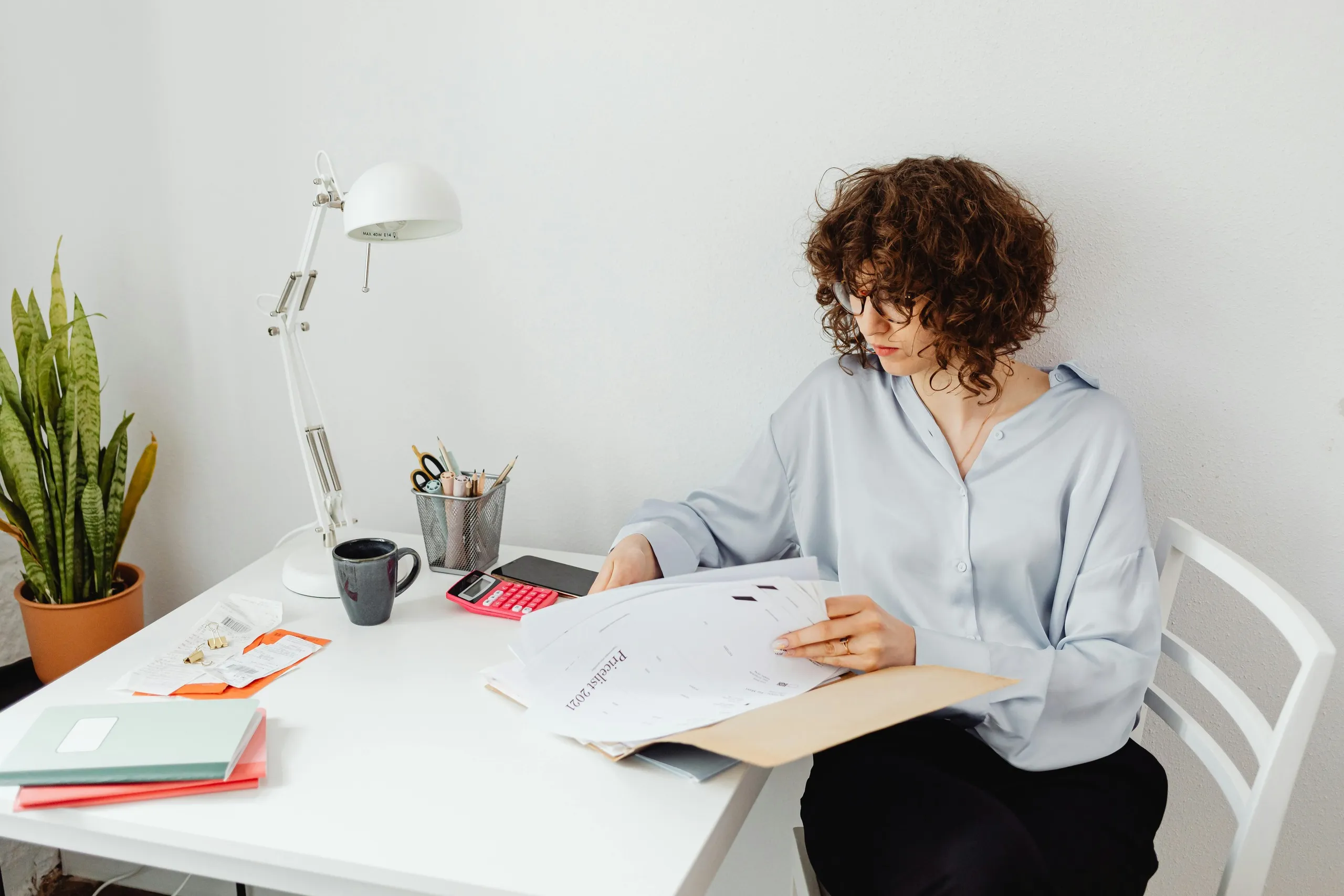 Businesswoman organizing financial documents as part of the virtual assistant vetting process for online bookkeeping.