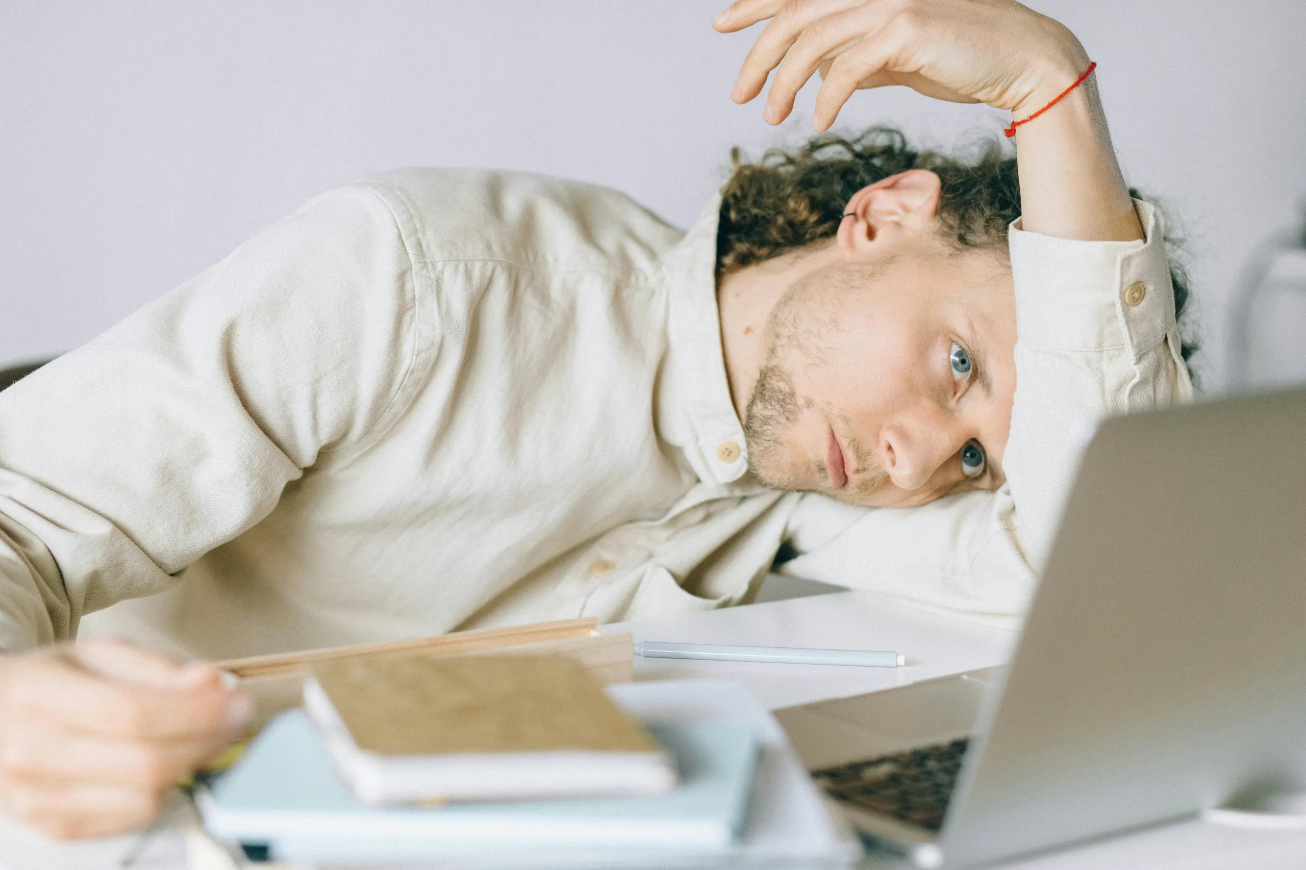 Stressed businessman reviewing financial documents, showing the consequences of bookkeeping mistakes without a skilled virtual bookkeeper.