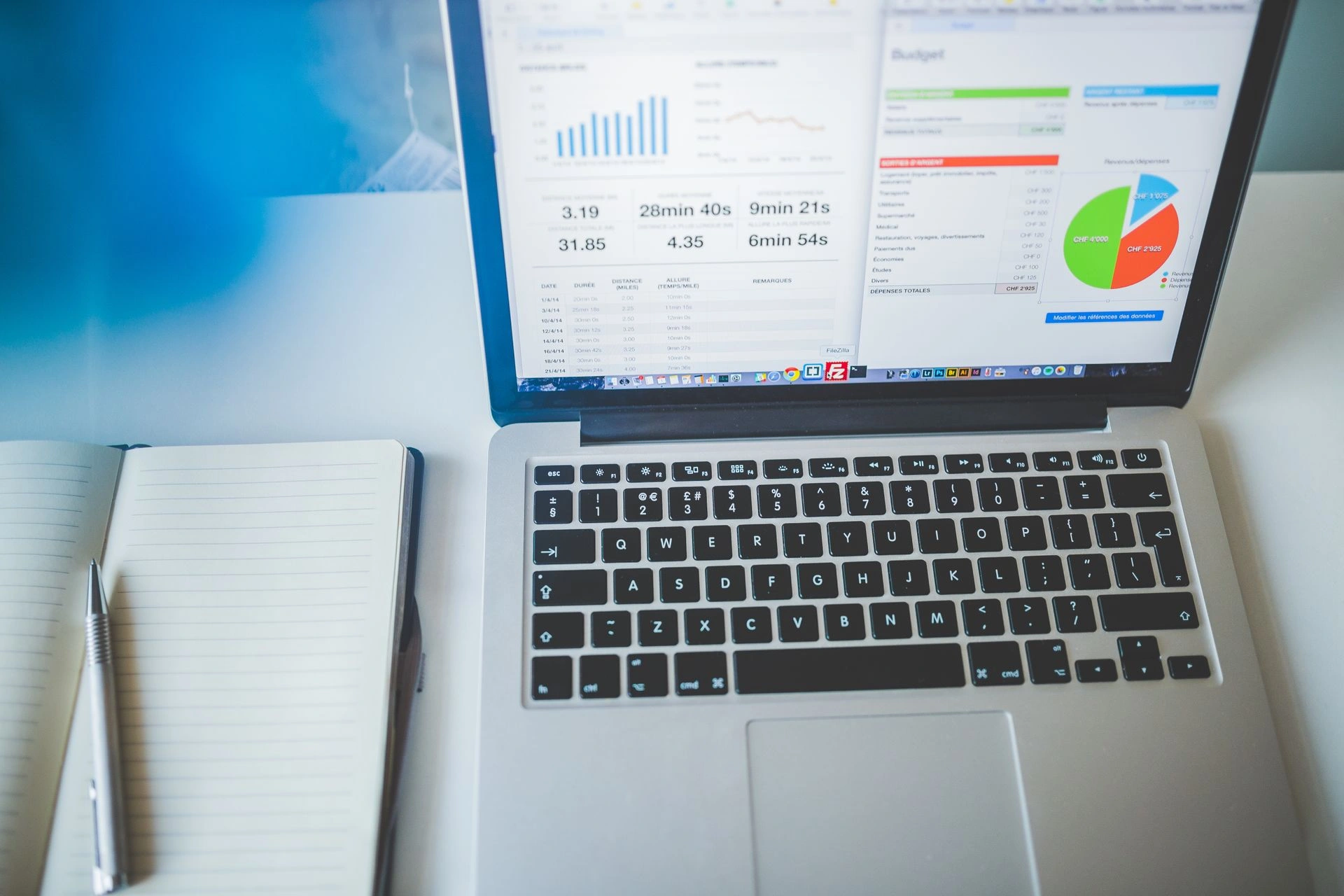 Laptop displaying analytics dashboards beside a notebook, representing AI-driven data and local SEO insights.